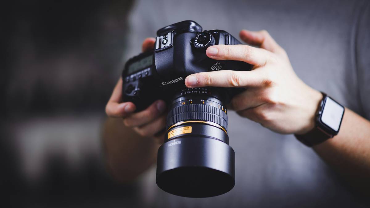 Photographer inspecting damaged camera gear with camera gear safeguard policy documents nearby